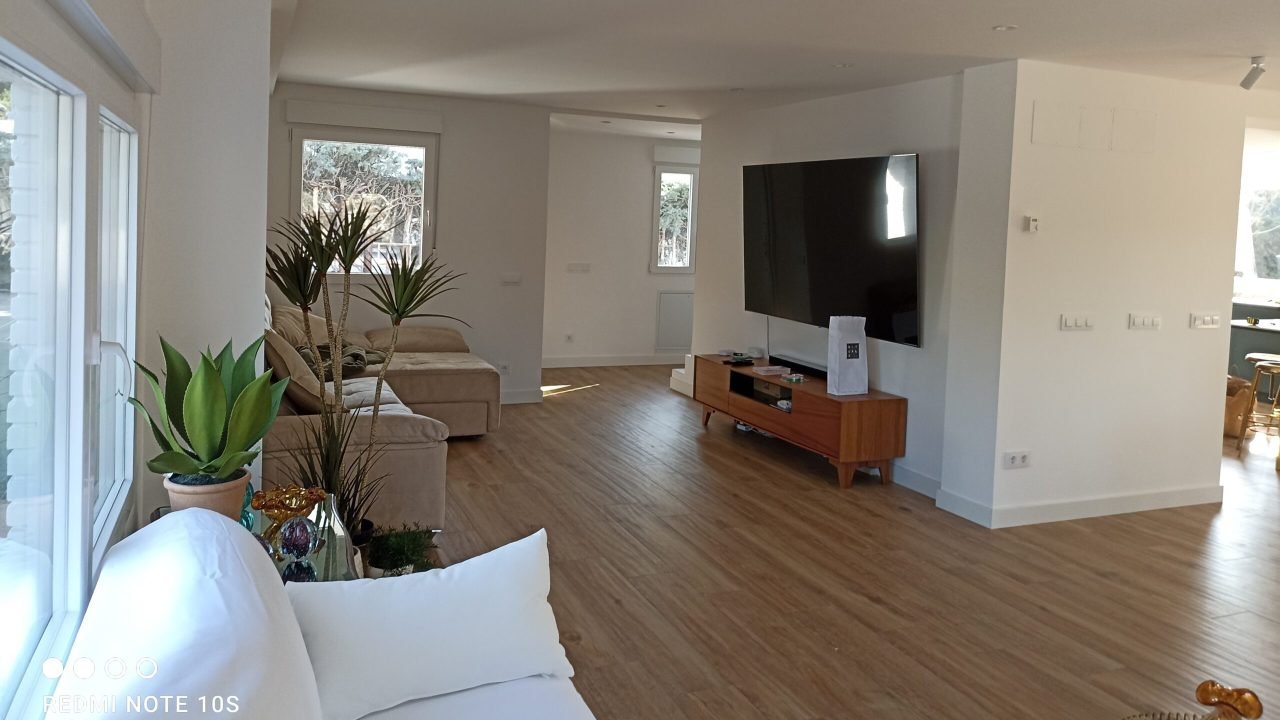 salón luminoso con sofá blanco y televisor